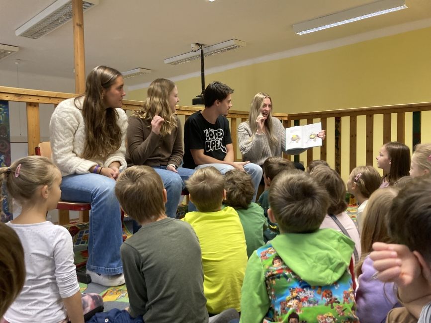 study abroad students read children