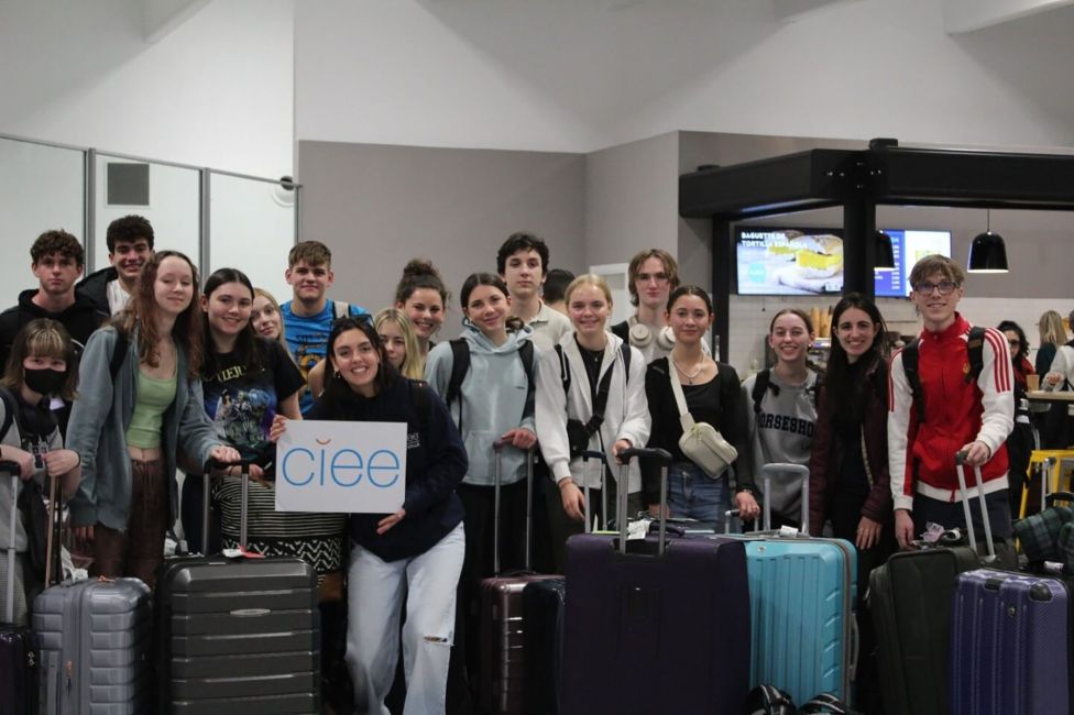 High school students at the airport holding CIEE sign