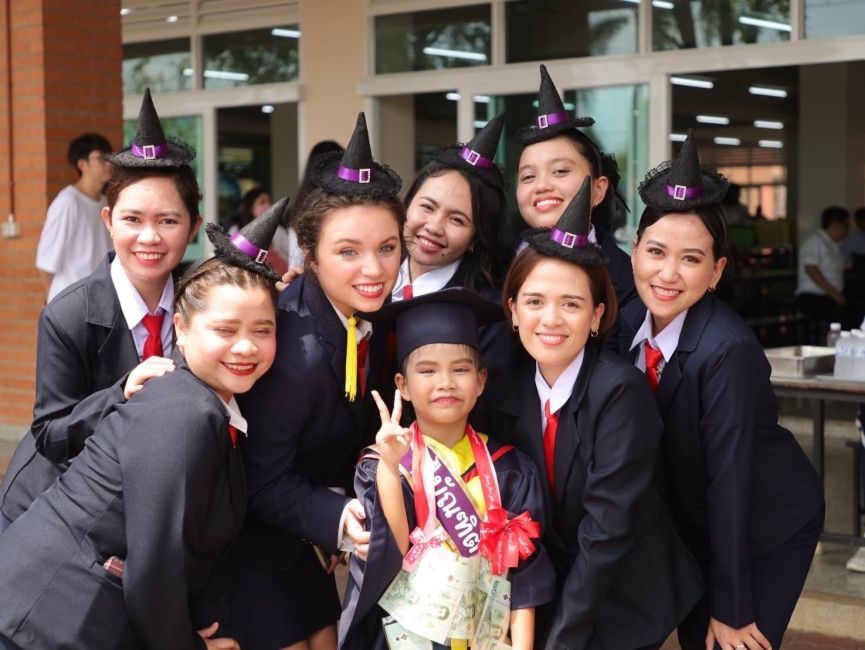 7 people pose for a picture in witch outfits for a graduation ceremony