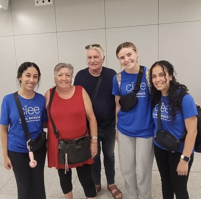 students with host family at airport 