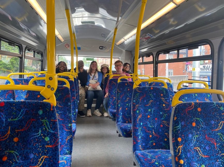 Students enjoy a ride on the second level of a double decker bus. 