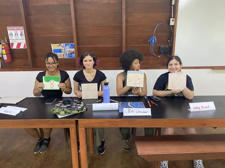 Students hold up an art project created in class.