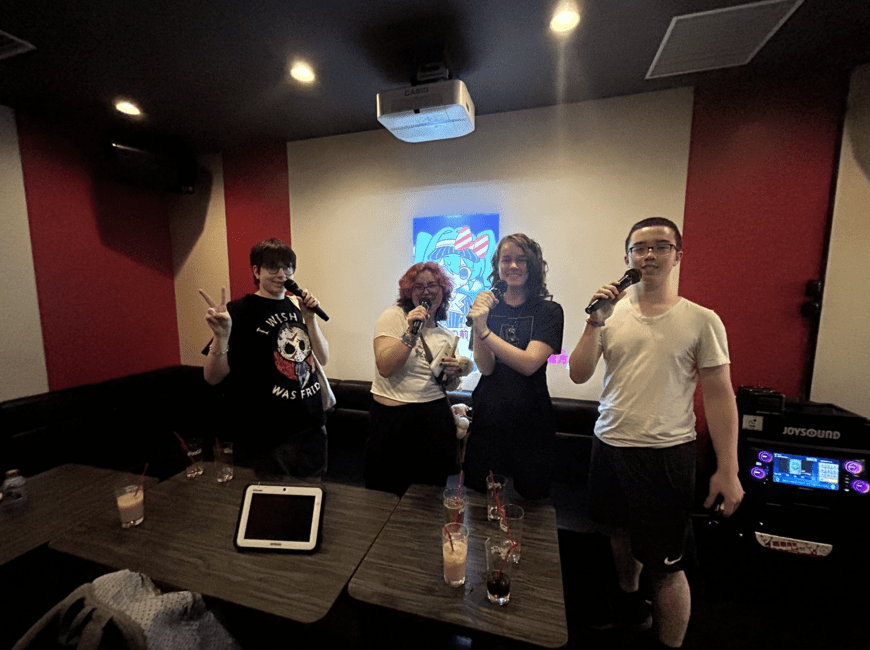students posing with microphones at karaoke