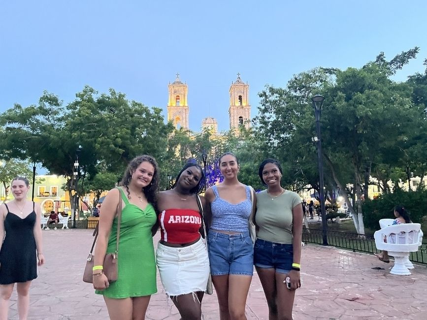 High school study abroad students in a park in front of a historic cathedral