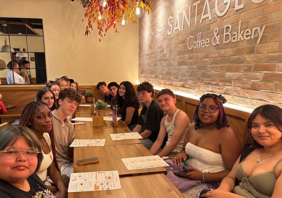 Students all sit together at a local cafe, laughing and getting to know one another!