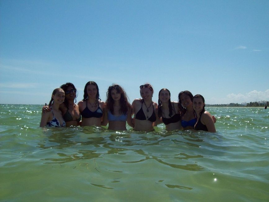 Many students standing in the water looking at the camera
