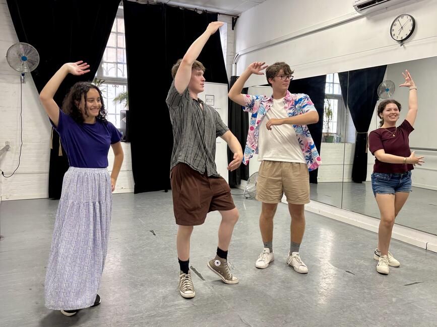 Students striking a pose after performing for the rest of their peers