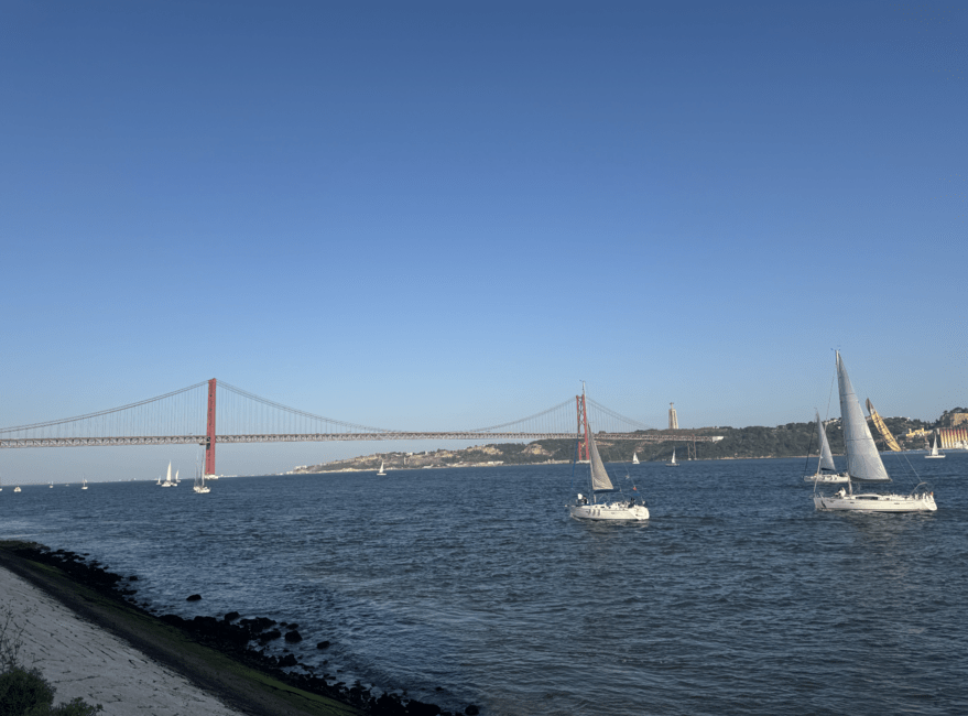 View from the MAAT in Belém, showcasing boats and the 25 de Abril bridge. 