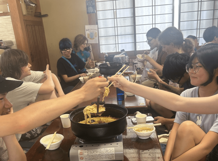 students taking noodles out of hot pot to eat 