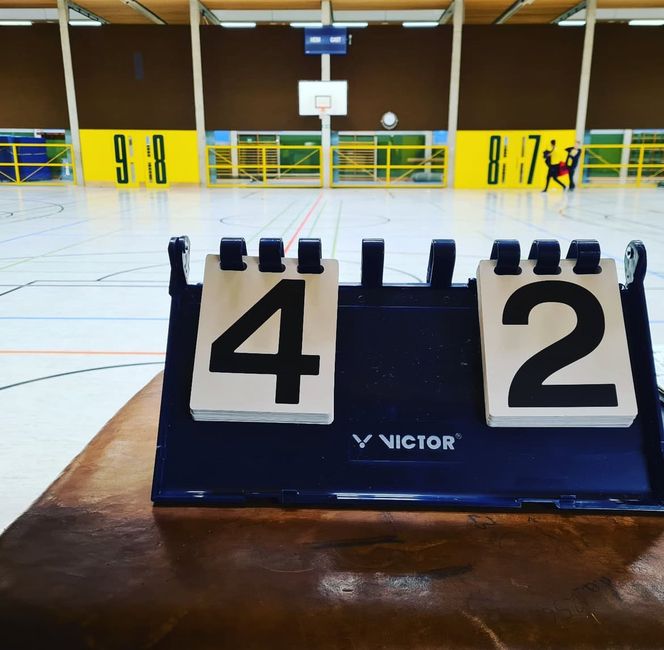 Hanna shows a badminton scoreboard.