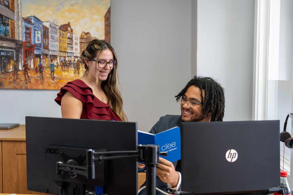 Students in front of computers looking at CIEE notebook