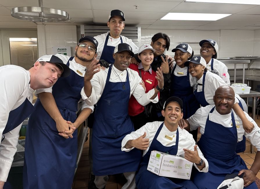 Lungelo K., at bottom right, poses with his coworkers at the Sea Island Company in Georgia. The South African native served as a CIEE BridgeUSA Trainee.