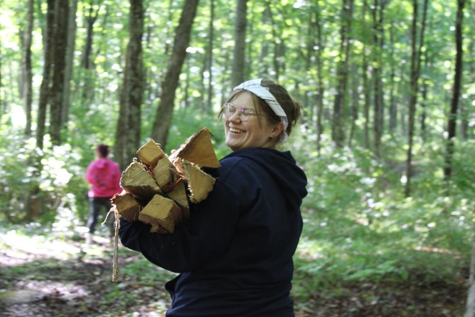 Venla S. of Finland carries firewood one afternoon at camp.
