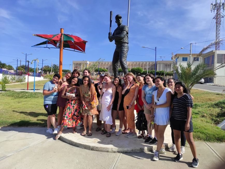 High school students posing by statue of baseball player in Santiago