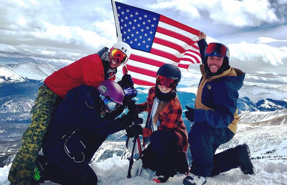 students snowboard and ski us flag