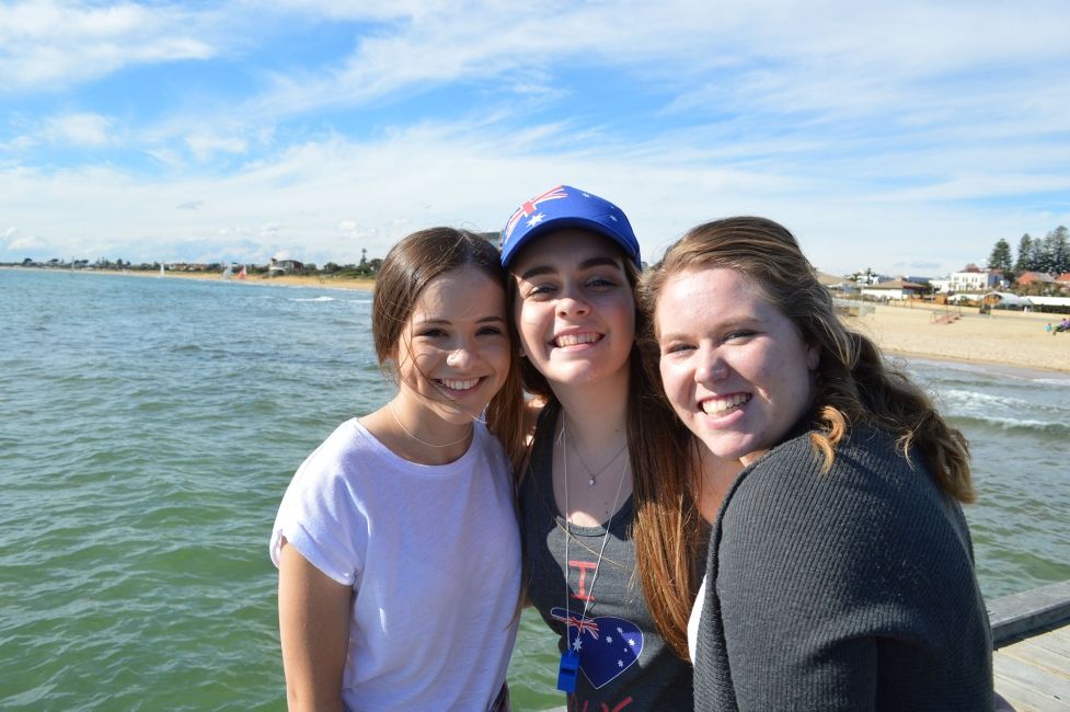 High school students smiling together on the beach