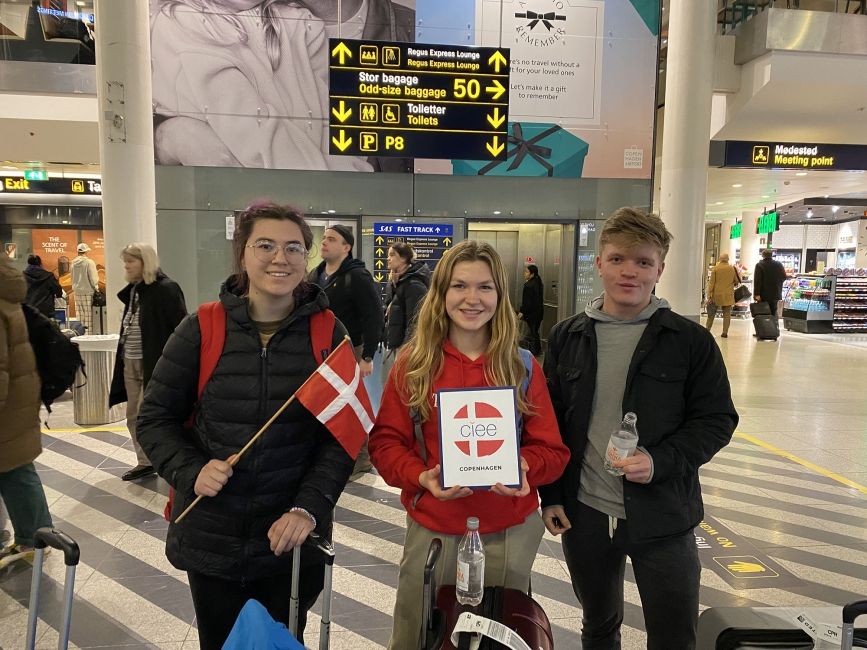 Students with the Denmark flag in the airport