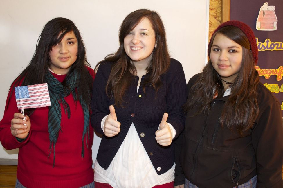 Teach in Chile participant giving thumbs up with Chilean students beside her