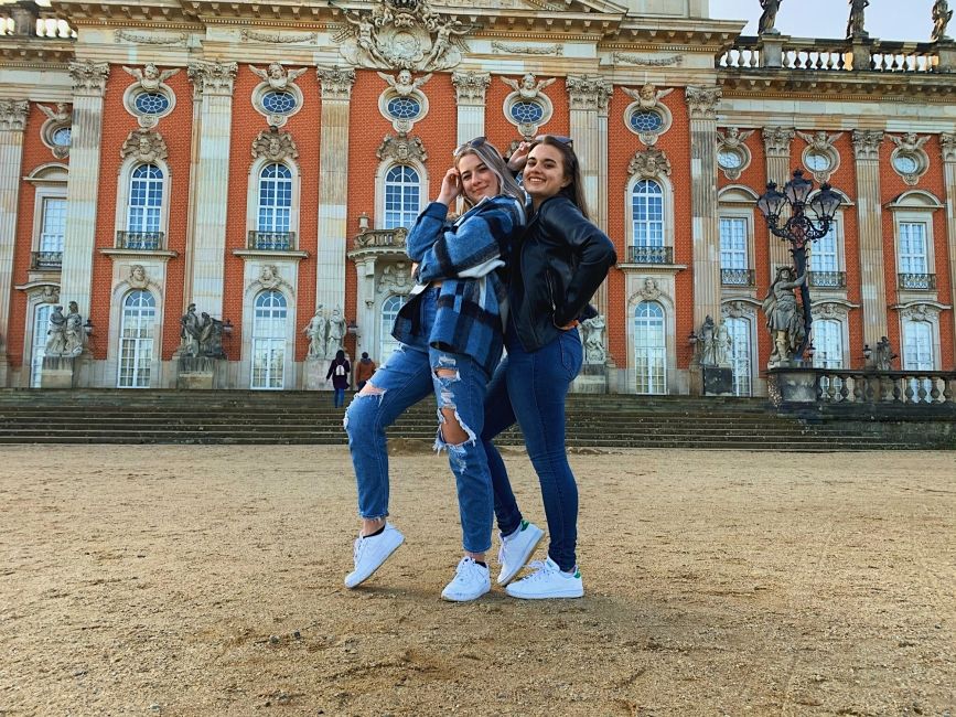 girls in berlin smiling by building