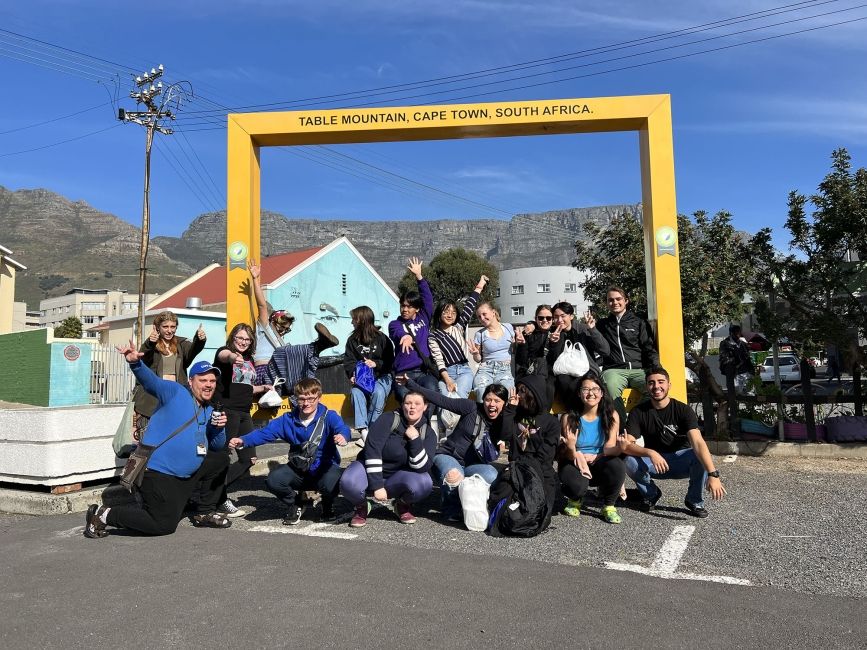 High school students posing with Table Mountain sign in Cape Town