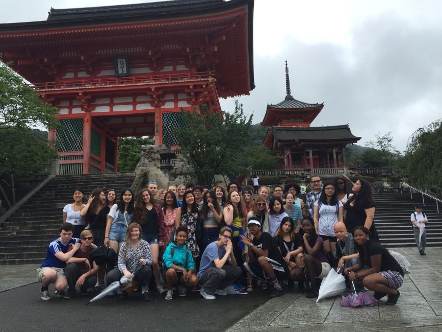 Group of high school students posing by the steps of a temple in Kyoto