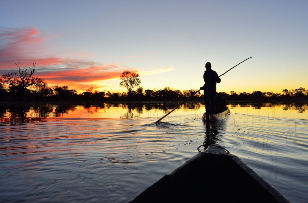 gaborone man on paddle boat in river at sunset