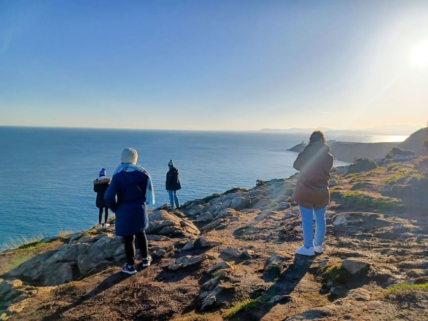 dublin students overlooking ocean on coastline