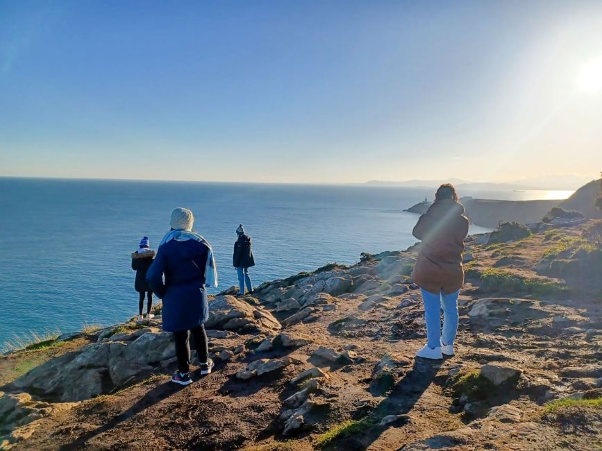 dublin students overlooking ocean on coastline
