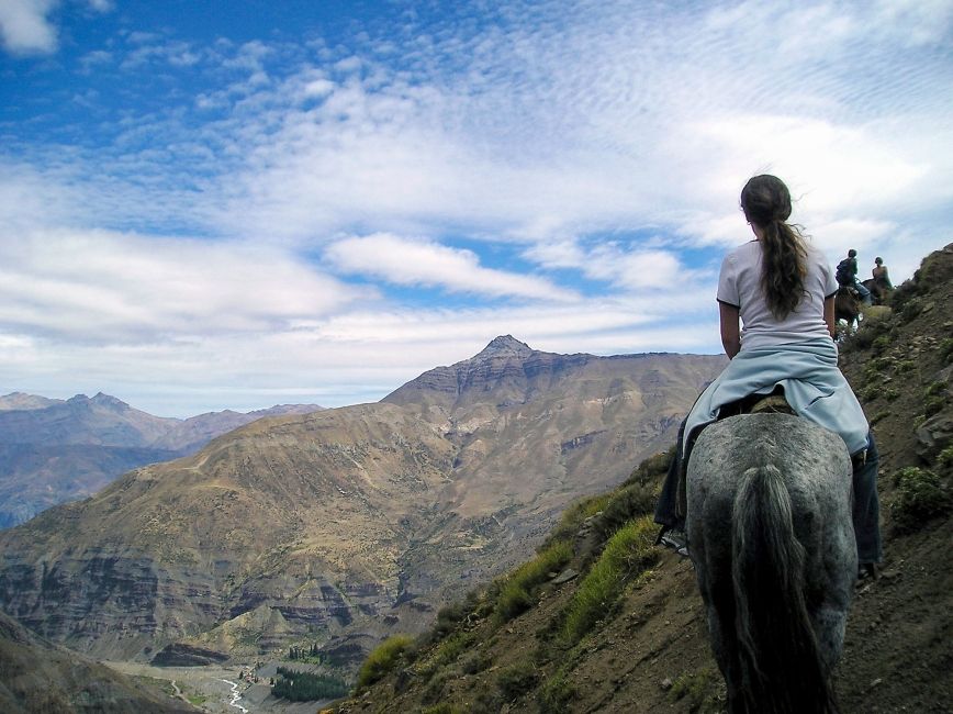 santiago ch girl riding a horse up a mountain side