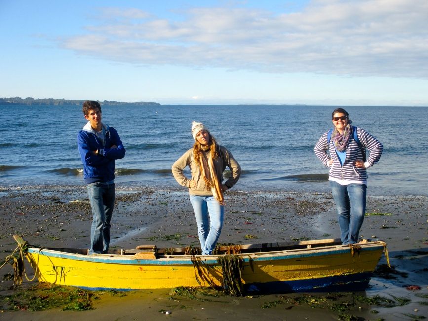 santiago ch three students standing in a beached boat