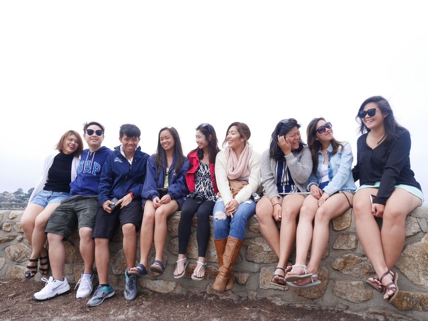 singapore students sitting on a rock wall