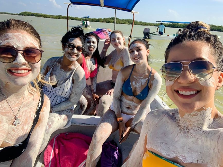 yucatan girls on boat wearing mud