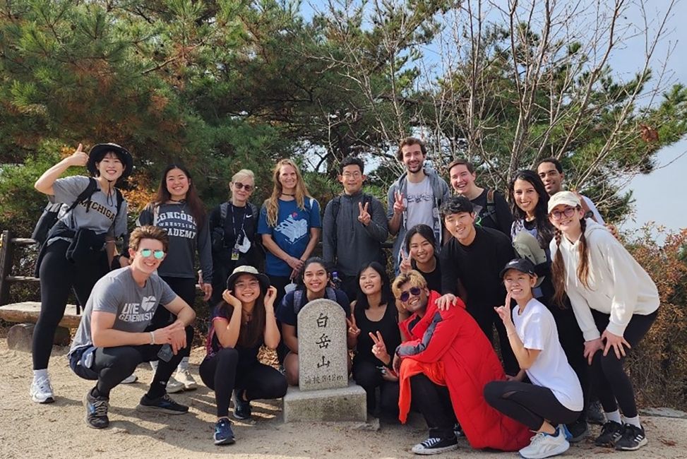 CIEE Seoul participants on hike posing with Seoul city wall marker