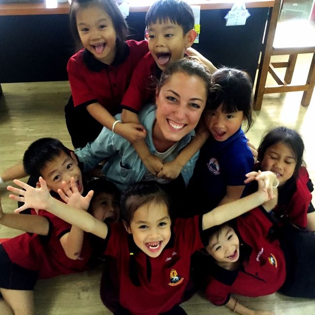 Teacher hugging students in Thailand classroom