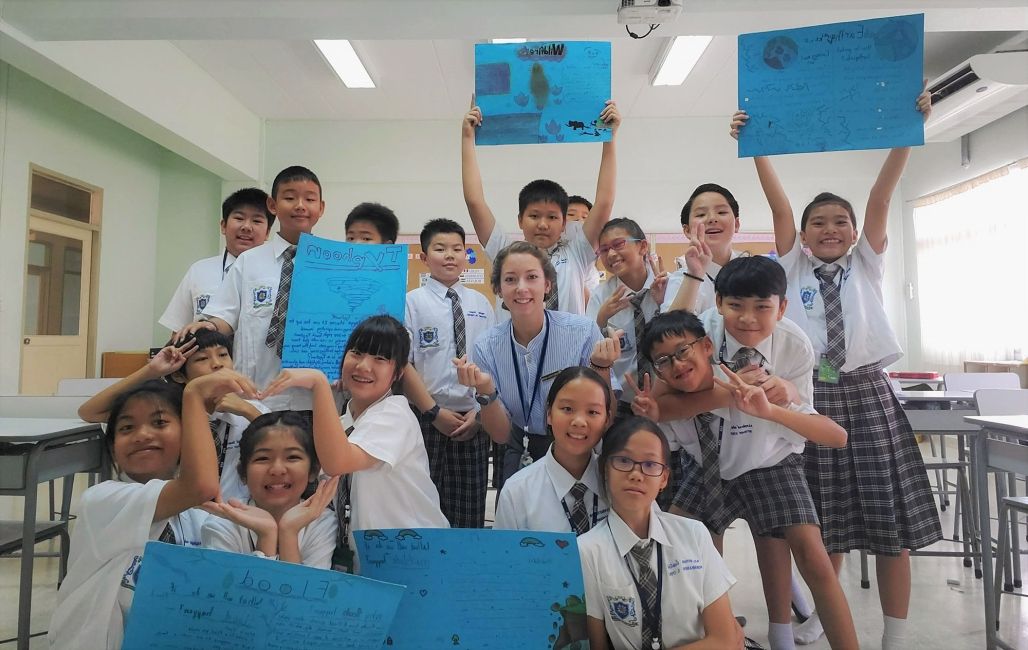 Thailand teacher with class holding up blue posters