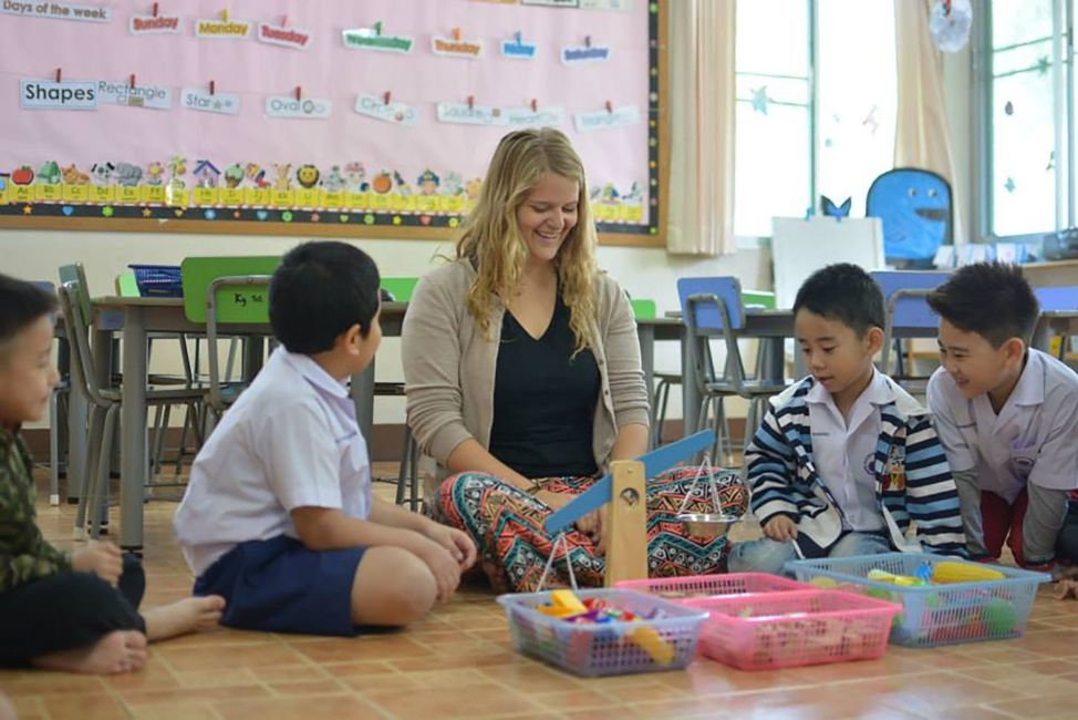 Teacher and students in Thailand in front of scale