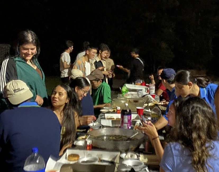 young (age 18-22) participants of the summer work and travel program sitting at a picnic table eating food and drinking soda