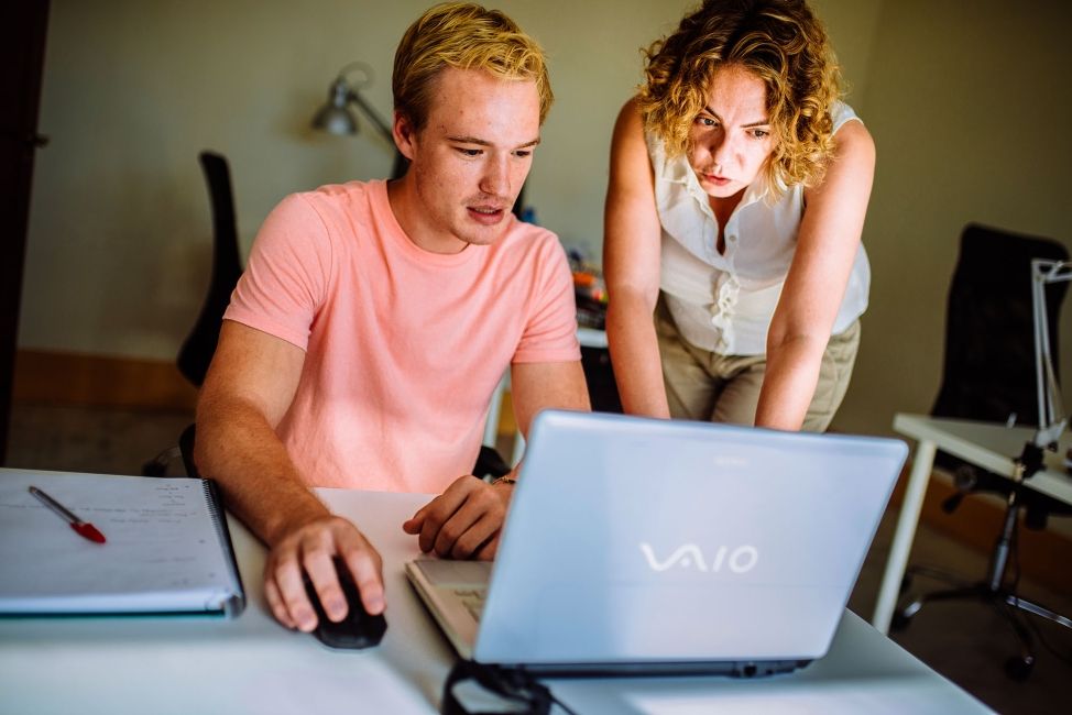 seville intern working at a laptop with a professional