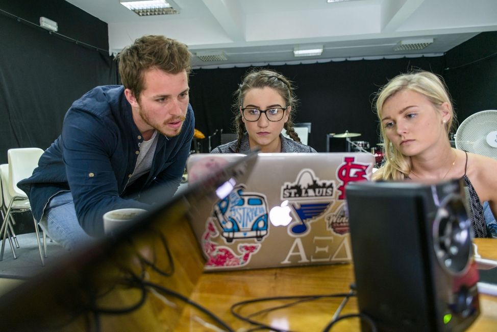 three seville interns working at a laptop