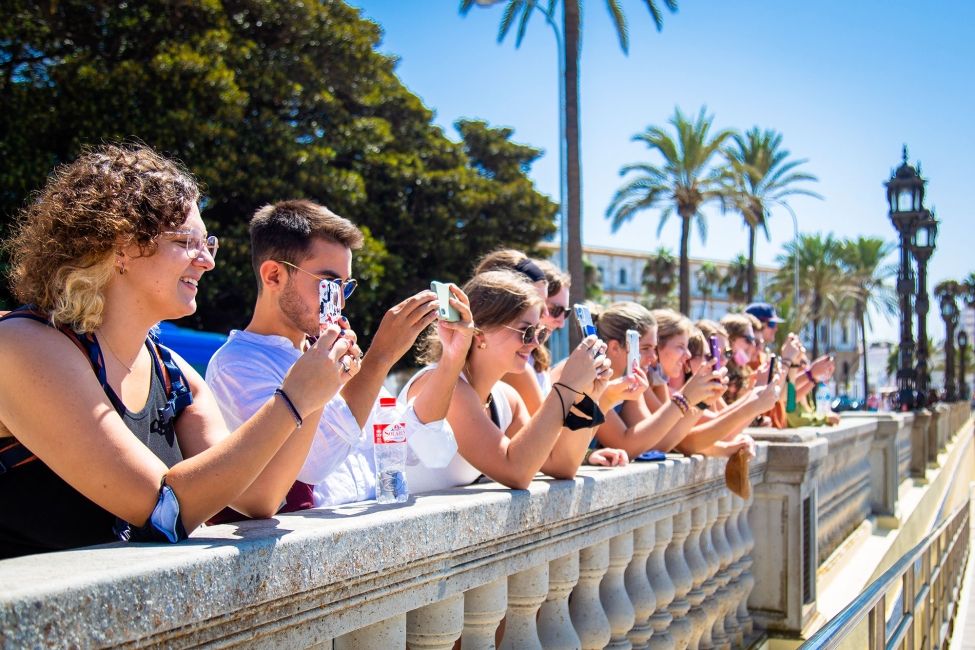 seville students on a bridge taking pictures with their phones