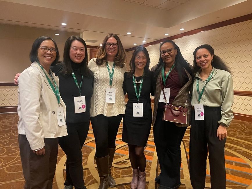 Six women standing with their arms around eachother posing for a picture wearing conference badges for The Forum on International Education's Annual Conference