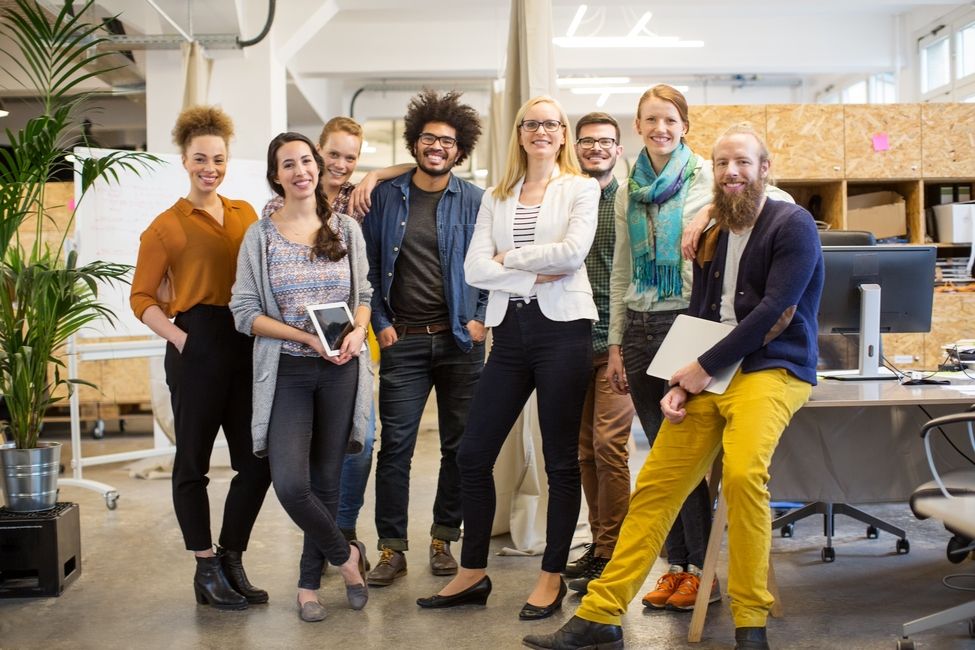 A group of people standing together in an office setting