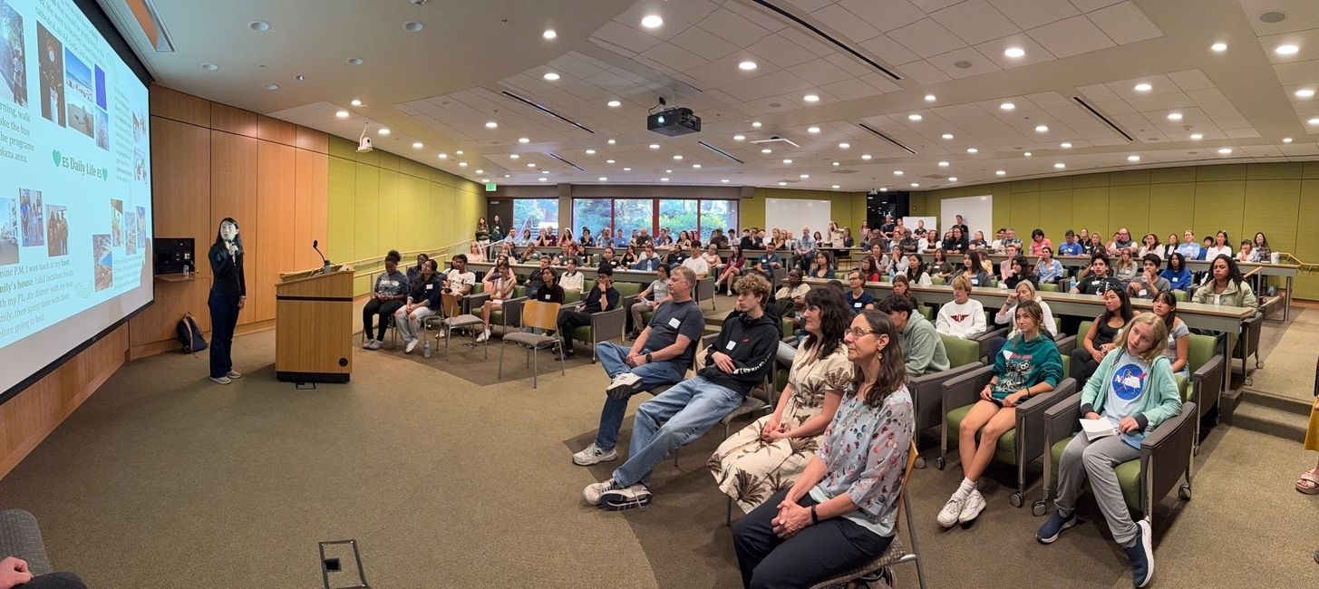 a wide shot of a large group people in a classroom