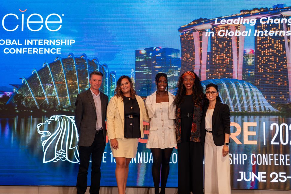  a group of 5 people on stage smiling