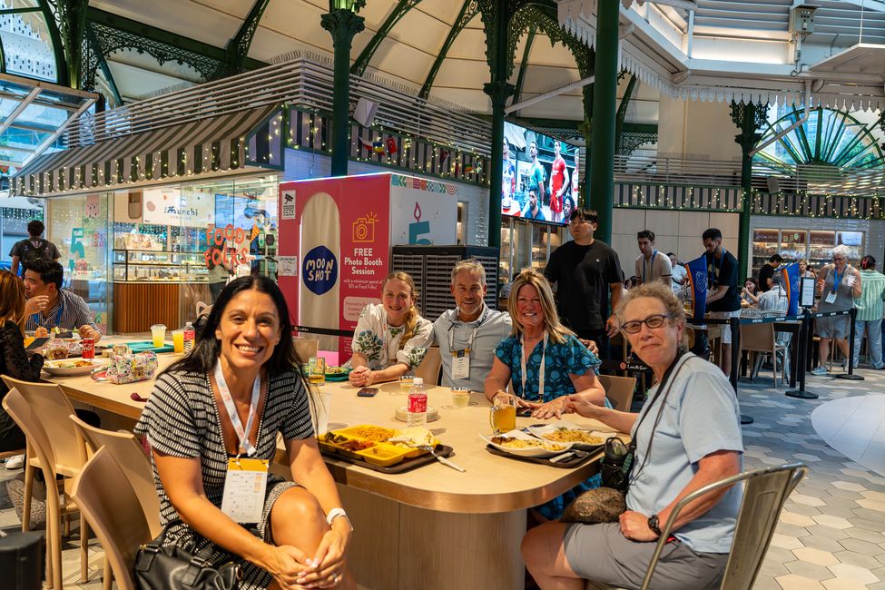 a group of people at a table eating and smiling