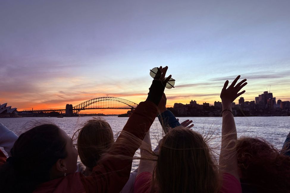 students-waving-their-hands-in-the-sunset-on-a-ferry-by-the-sydney-harbour-bridge.jpeg