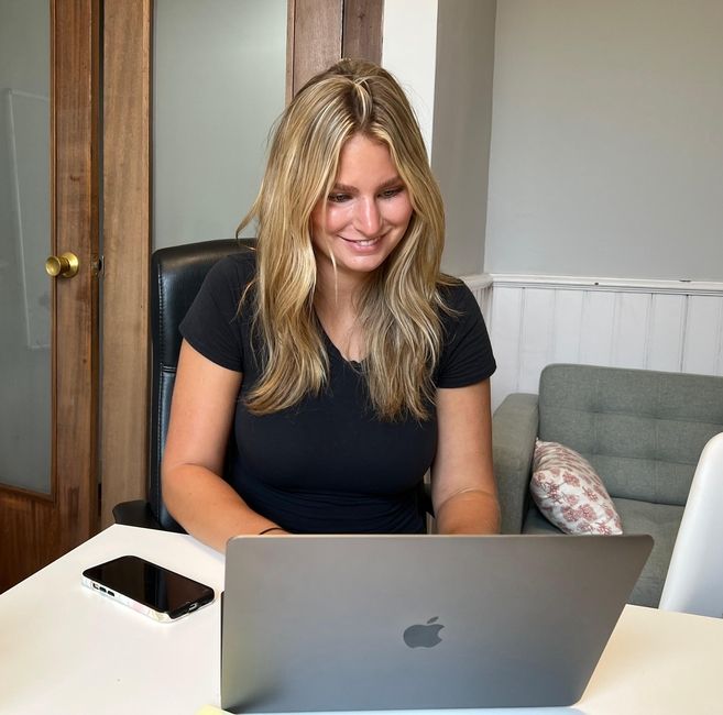 An intern sits at a table during a meeting.