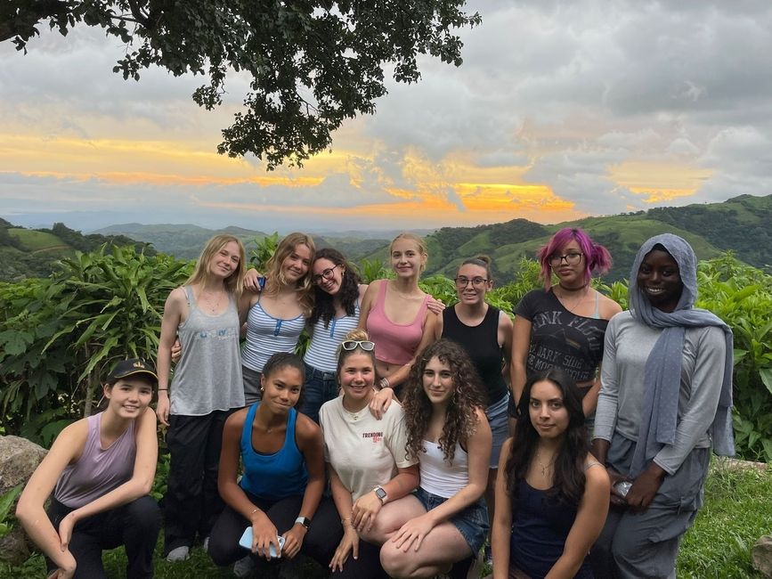 Monteverde high school students posing in front of a forest sunset