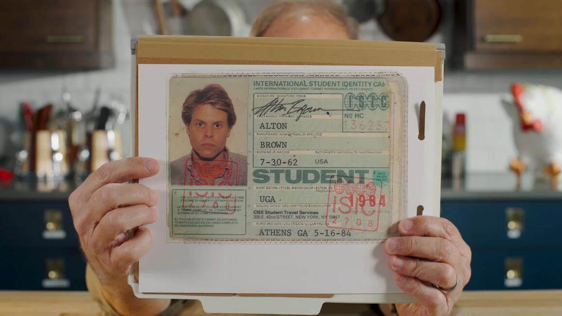  Alton Brown Cooks Food, holding his ISIC card