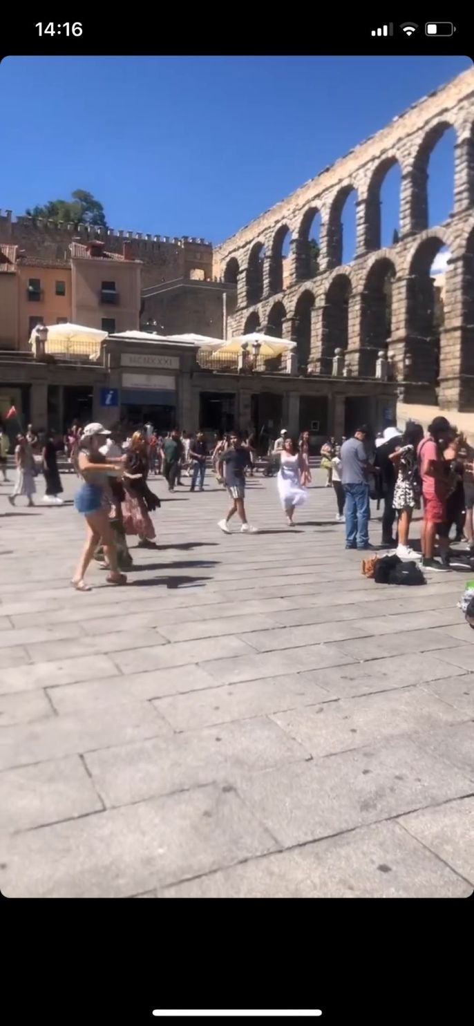 A group of people playing instruments gathered in the center with students and other individuals dancing around the outside